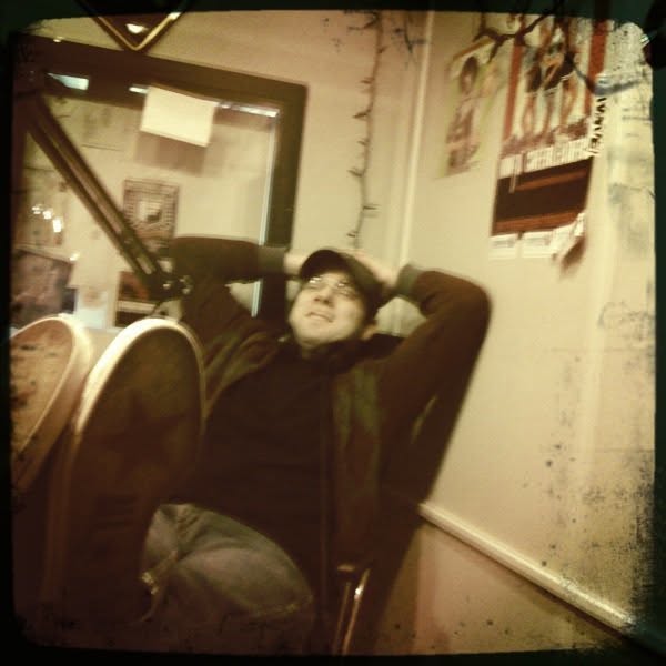 Mike Cioffi leaning back with his feet up in the studio